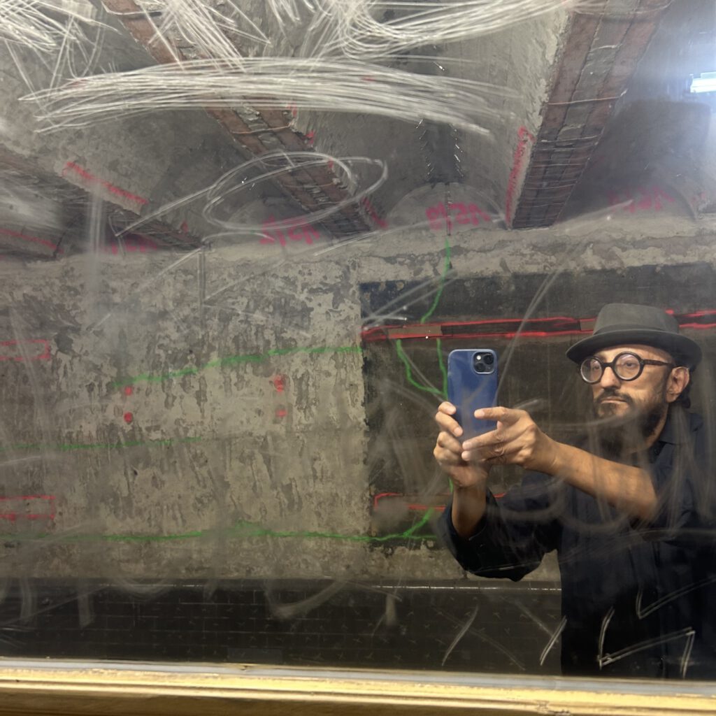 the artist portraits himself in a mirror in the subway
